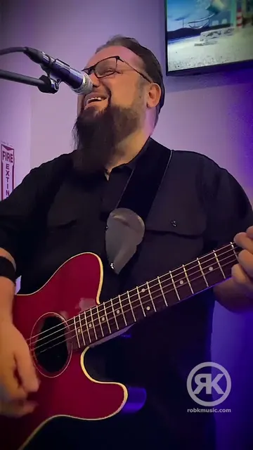 Rob Kosinski singing and playing acoustic guitar